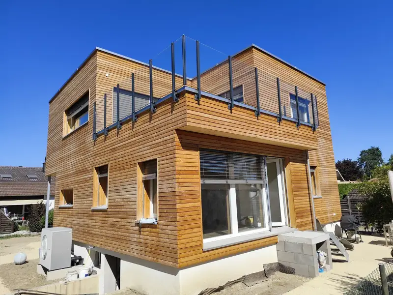 Glasgeländer Pure auf der Dachterrasse, Pfosten seitlich an der Holzfassade montiert – Kundenprojekt in Luterbach SO