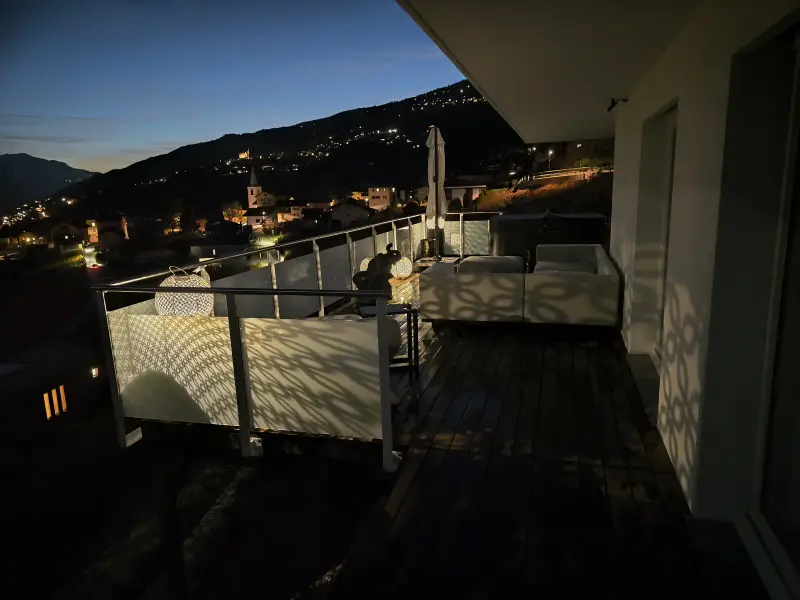 Terrasse mit Glasgeländer Classic und Mattglas bei Nacht, im Hintergrund die Lichter am See