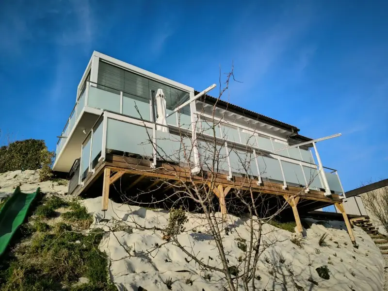 Glasgeländer Classic mit Mattglas an einer Holzterrasse in Hanglage