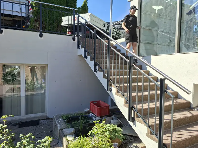 Kundenprojekt Flex: Treppengeländer anthrazit mit Edelstahlhandlauf, seitlich an der Betontreppe