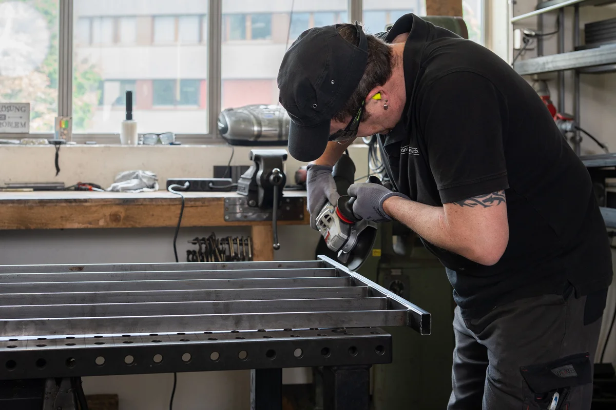 Fächerscheibe auf Winkelschleifer beim Kantenbrechen an einem Stahlprofil